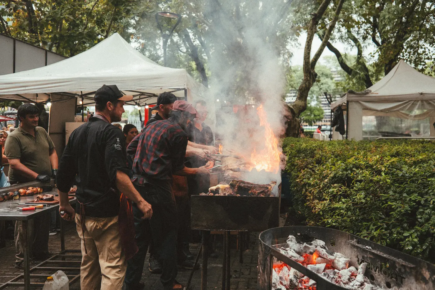 Mehrere angehende Asadors stehen vor dem Grill