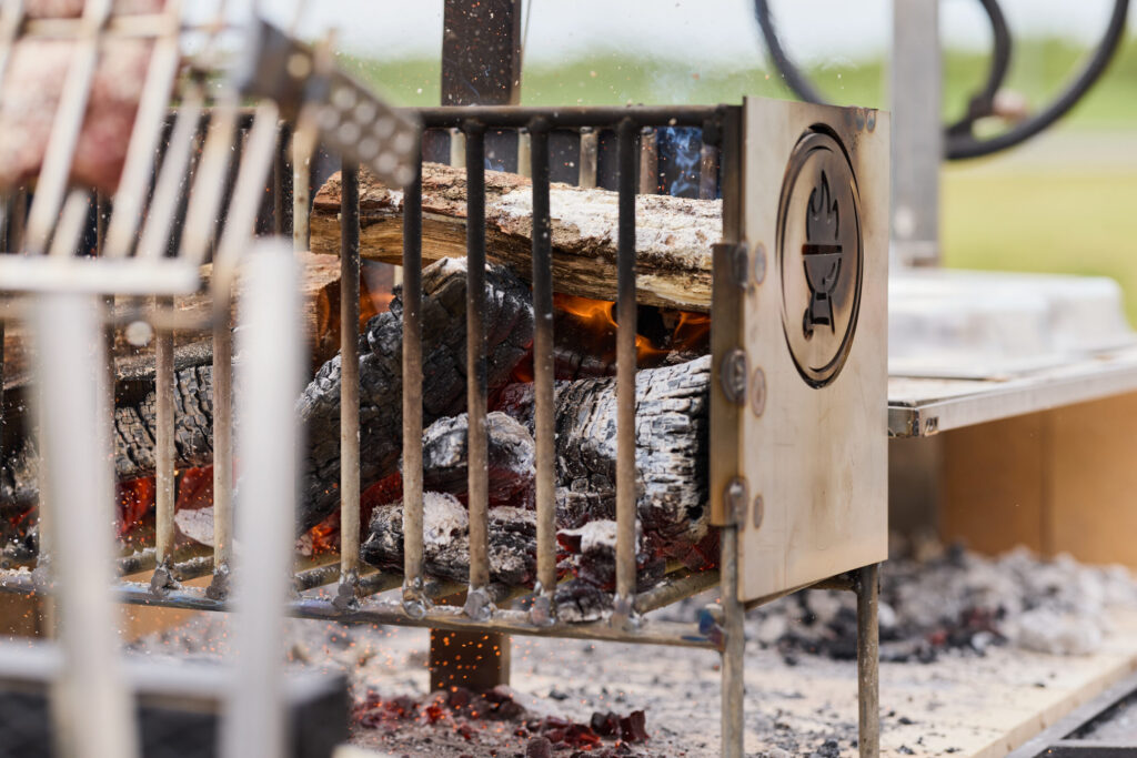 Brennendes Holz im Feuerkorb des Asado Grills